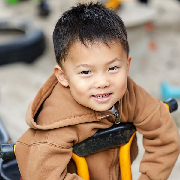 image shows a kinder boy riding a bike at his kindergarten.jpg